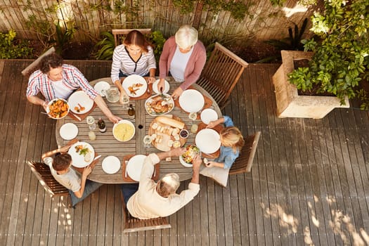 Nothing brings people together like good food. High angle shot of a family eating lunch outdoors.