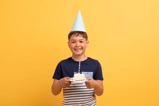 Happy handsome cute birthday boy holding birthday cake