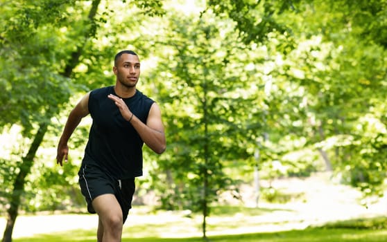 Serious attractive millennial african american man athlete sprinter training, running at summer park