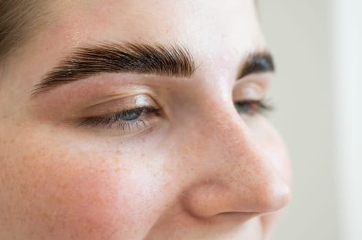 Close-up portrait of a woman after the procedure of correction and lamination of eyebrows.