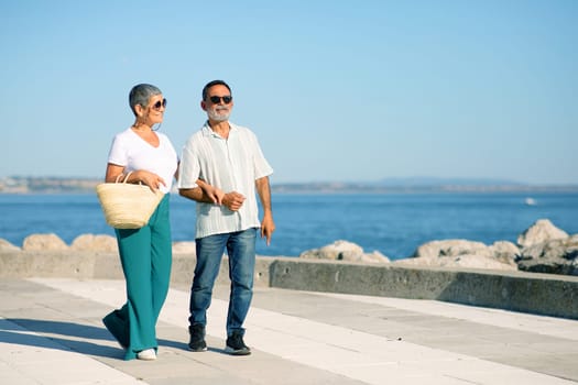 Senior Spouses Walking Along Promenade By Sea Outside, Free Space