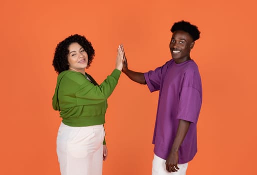 Positive young multiethnic lovers giving each other high five