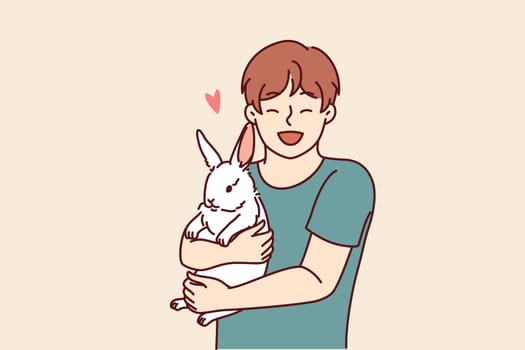 Boy with little rabbit laugh hugging beloved pet for concept of love for domestic animals