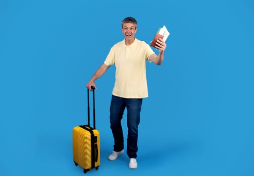 Gray Tourist Man With Suitcase Posing Showing Tickets, Blue Background