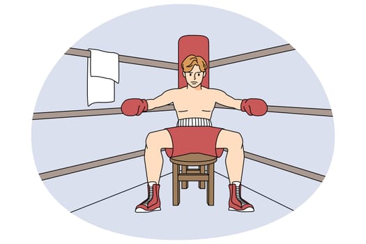 Male boxer sit in ring preparing for match