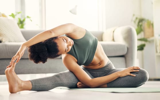 Stretching, yoga and woman on a living room floor for training, exercise or mental health at home. Legs, stretch and lady with flexible fitness or pilates workout for balance, meditation or wellness