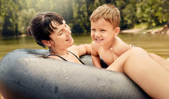 Lake, swimming and parent with kid in water while camping in a forest for vacation or holiday together. Travel, swimming and mother bonding with child in nature for freedom, love and happiness