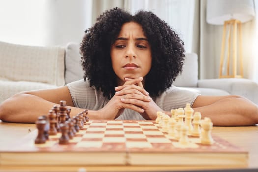Thinking, strategy and face of woman with chess for problem solving, planning and challenge at home. Competition, contest and female person with chessboard in living room ready for playing games
