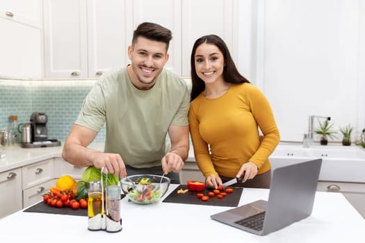 Smiling attractive man and woman preparing delicious dinner together