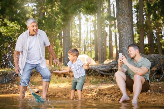 Nature, lake and child with his grandfather and father playing, fishing and bonding on a vacation. Travel, happy and senior man having fun with adult son and grandchild in the woods on a weekend trip