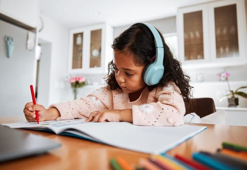 Young child, learning and homeschool with headphones for homework, writing and drawing in books. Childhood development, focus and girl kid listening to audio while studying for kindergarten education