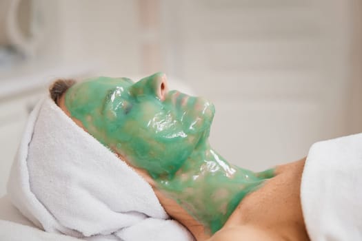 beautiful woman with green alginate mask on face