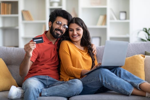 E-Commerce Concept. Smiling Young Indian Spouses Using Laptop And Credit Card