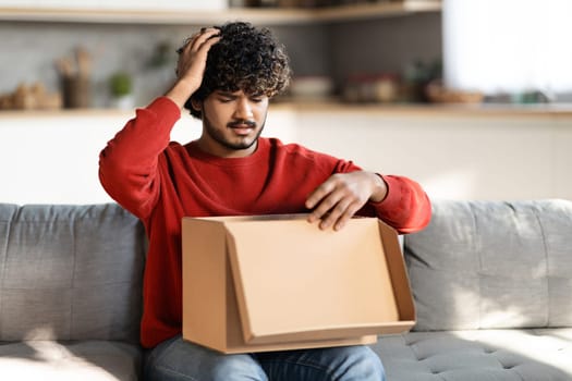 Upset Indian Man Opening Post Parcel And Touching Head In Shock
