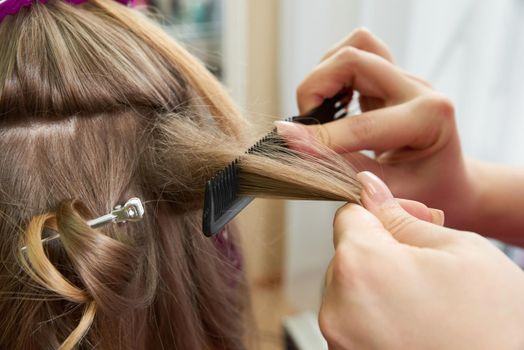 Hairdresser styling hair of a client in beauty salon