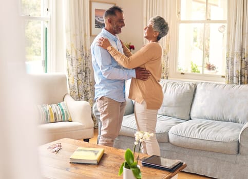 Love, romance and dance with a senior couple in the living room of their home together for bonding. Marriage, retirement or bonding with an elderly man and woman dancing in the lounge of their house.