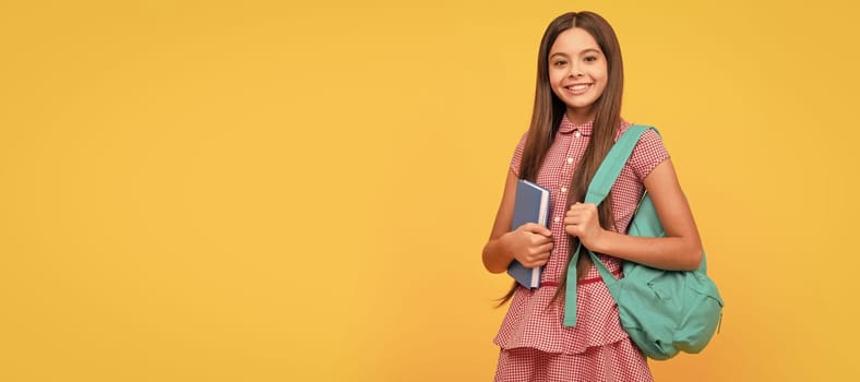 happy kid with workbook on yellow background. Banner of schoolgirl student. School child pupil portrait with copy space.