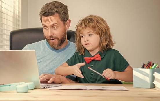 amazed father and child son at school working online on laptop, amazement
