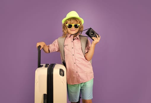 Child travel with travel bag. Child with suitcase dreams of travel, adventure, vacation. Studio kids portrait.