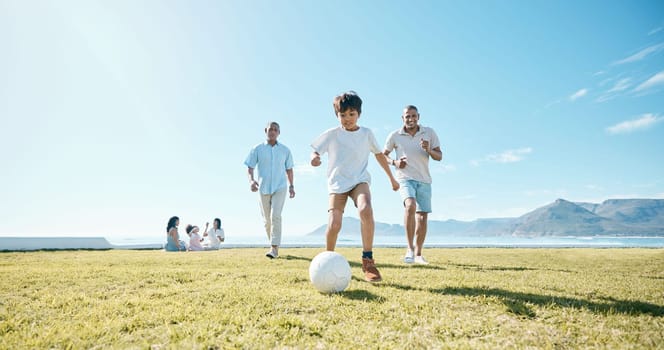 Family, soccer and men with ball in a park for fun, playing and bonding in nature on blue sky background. Sports, games and boy child with father and grandfather outdoors for weekend football match