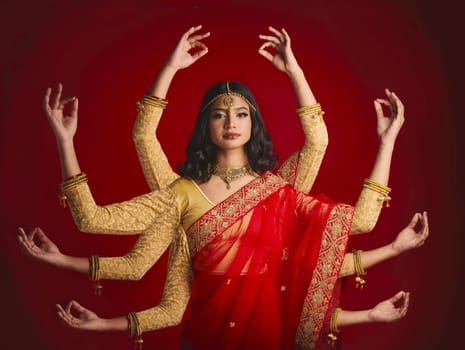 Indian woman, portrait and goddess with many hands in studio background with sari and jewellery. Mudra, girl and beauty face with meditation with dress or movement with culture or spirituality.