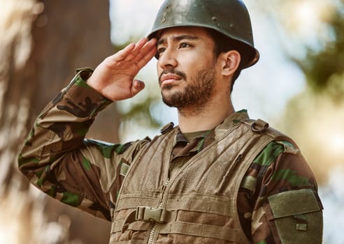 Soldier, military and man salute in nature for service, protection and battle training outdoors. War, national army and male person in position for veteran honor, greeting and official duty in woods