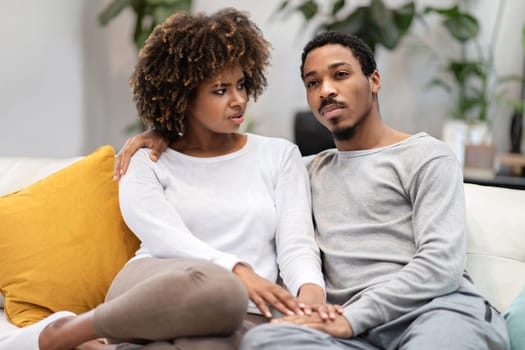 Worried young african american woman looking at her boyfriend