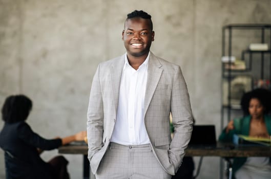 Toothy Black Businessman Standing Posing With Confidence In Modern Office