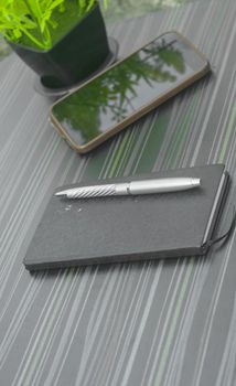 Pen and notebook on office table. Table top view. Corporate business background.
