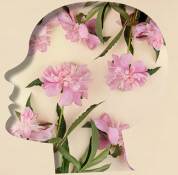 Human head silhouette, pink peonies in the middle