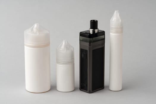 Electronic cigarette with re-fill liquid bottles on gray background