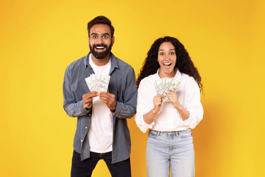 Rich Middle Eastern Spouses Holding Money Dollar Cash, Yellow Background