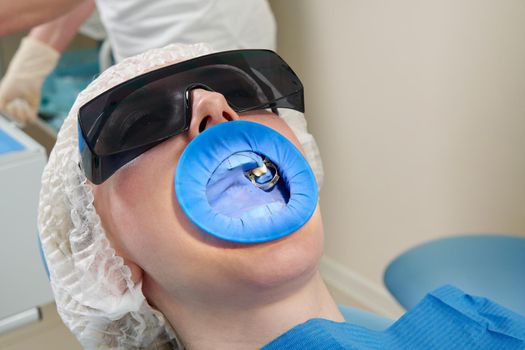 Young woman getting dental treatment at dentist office with a dental rubber dam protection