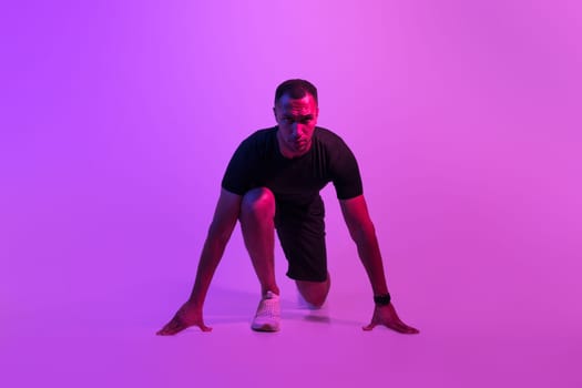 African American Runner Guy Doing Crouch Start On Purple Background