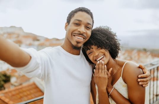 Happy satisfied millennial african american man hugging woman with ring, making selfie, video call