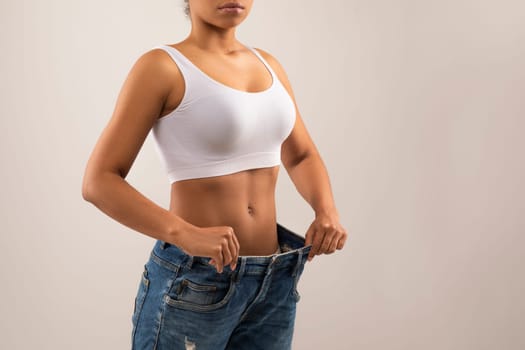 Cropped of black woman wearing big jeans after weight loss