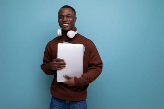 young american sound producer with laptop and headphones on background with copy space