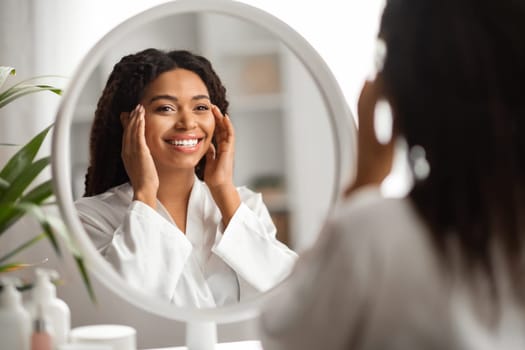 Beauty Concept. Portrait Of Attractive Young Black Woman Looking At Mirror And Touching Face, Beautiful African American Female Enjoying Her Flawless Skin Without Wrinkles And Smiling To Reflection