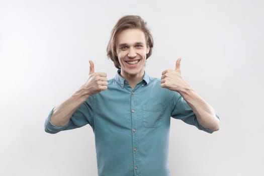Smiling satisfied man showing like gesture, thumbs up, recommend something, positive feedback.