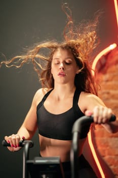 female running on elliptical orbitrek machine in fitness gym.