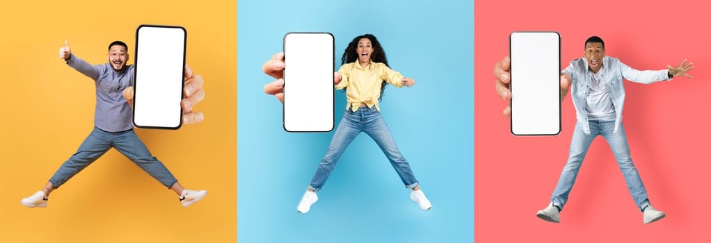 Glad young multiracial people jumping from joy and show phone