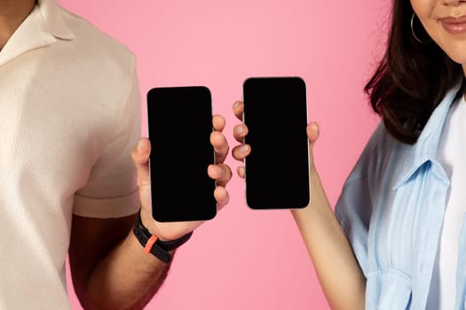 Cropped of man and woman showing smartphones with black screens