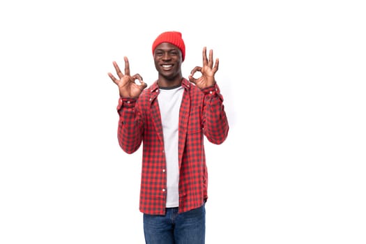 slick young african man in plaid shirt with hand gesture over isolated white background