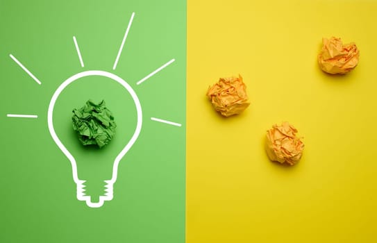 The concept of inspiration with new ideas, the search for creative solutions, crumpled sheets of paper in the form of balls on a green yellow background