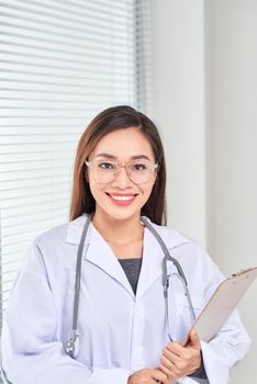Portrait of smiling female doctor standing posing in her hospital office., Healthcare and medical occupation concept.