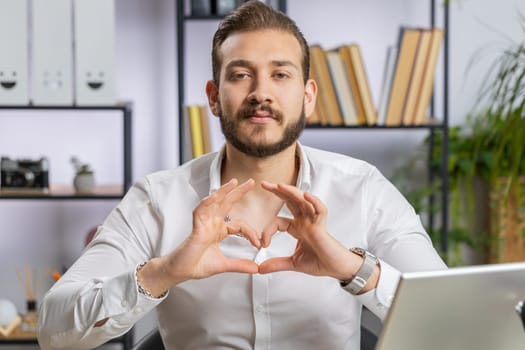 Lebanese business man makes symbol of love, showing heart sign to camera, express romantic feelings