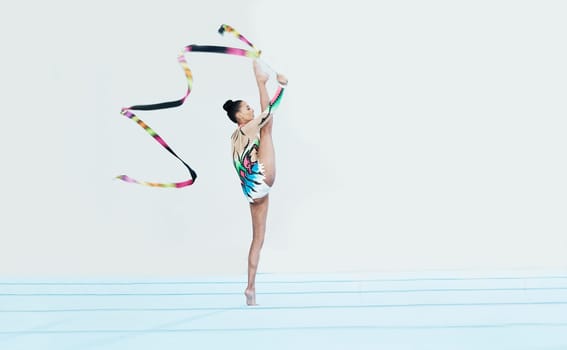 Gymnastics performance, woman and ribbon with legs split for competition, sport and show on studio floor. Gymnast, athlete girl or professional dancer for balance, training or contest for creativity
