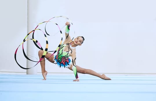 Gymnastics woman, ribbon and floor in portrait, competition or sport for fitness, performance or studio. Gymnast, athlete girl and professional dancer with balance, exercise or contest for creativity