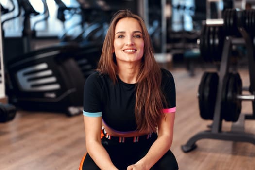 Woman fitness trainer portrait on a gym background