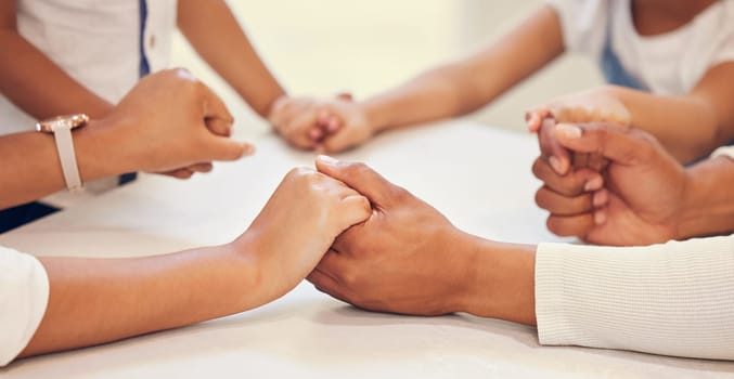 Parents, children and holding hands for praying in a closeup with unity, support and connection at home. Gratitude, family and grace hand on a table in the house for faith, worship and peace.